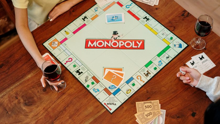 due persone al tavolo che giocano al gioco monopoly